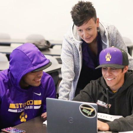 Two students with instructor near computer